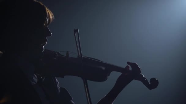 小提琴手在黑暗的演播室里表演 灯光下有一个灯笼的影子 黑色背景 — 图库视频影像