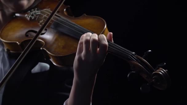 Violinist holds a bow and plays . Black background. Close up — Stock Video