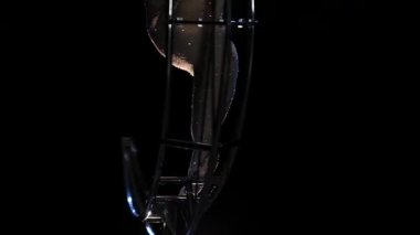 Bir ay şeklinde dönen üzerinde akrobatik hareket hileler karanlık bir stüdyoda gerçekleştirir. Siyah arka plan. Ağır çekim