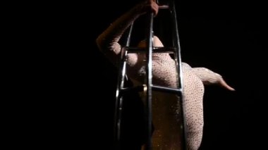 Zarif jimnastikçi özel tasarım ay karanlık bir odada hileci gerçekleştirir. Siyah arka plan. Ağır çekim. Yakın çekim