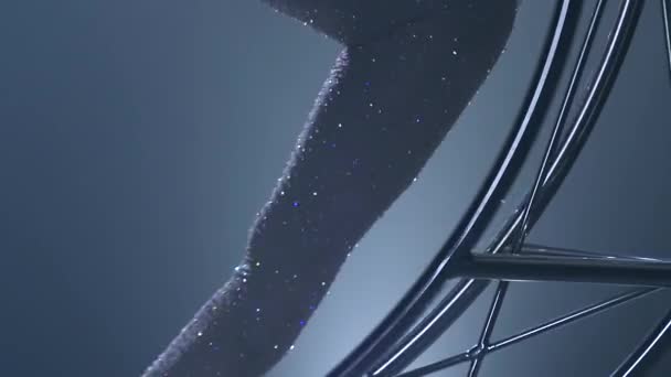 Ritmische gymnastiek de glijdt op één arm in de lucht op een metalen maan roterende structuur. Blauwe rook achtergrond. Slow-motion. Close-up — Stockvideo