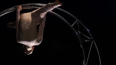 Jimnastikçi vücut üzerinde dönen bir tasarım ay karanlık bir stüdyoda. Siyah arka plan. Ağır çekim. Yakın çekim