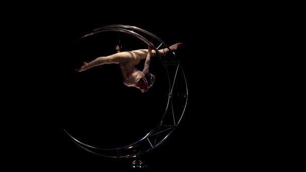 Gimnasta en un cordel en una luna de metal giratoria. Fondo negro. Movimiento lento — Vídeos de Stock