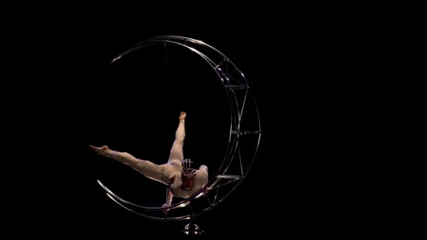 Gymnast in een touw op een roterende metalen structuur maan. Zwarte achtergrond. Slow motion — Stockvideo