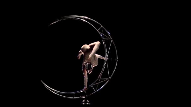 Gimnastyk nogami wisi w sznurka na obracającego się księżyca. Czarne tło. Zwolnionym tempie — Wideo stockowe