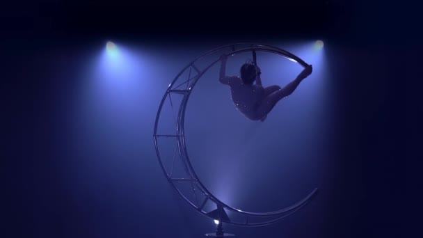 Витончений гімнаст виконує трюки на спеціальному дизайні в темній кімнаті. Синій дим фону. Повільний рух — стокове відео