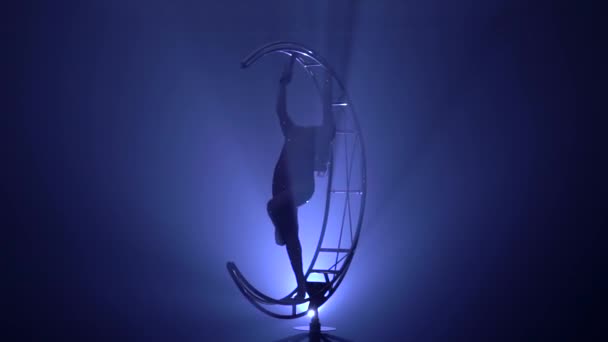 acrobaties d'art sur le design qui tourne sur la lune dans la pièce sombre floue avec de la fumée bleue. Fond de fumée bleue. Mouvement lent.Silhouette 