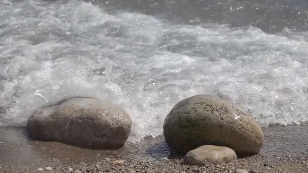 Spatten van water uit de golven breken op de stenen. Slow motion — Stockvideo
