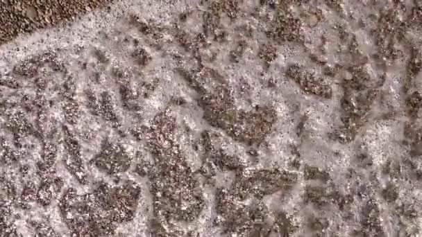 Water is het wassen van het strand dichtbij. Slow-motion. Bovenaanzicht — Stockvideo