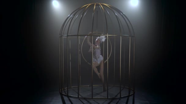 Discours sur acrobate de scène dans une cage tournant sur le cerceau aérien. Fond de fumée noir — Video