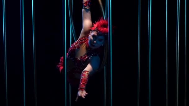 Actress a girl in a red shiny costume on a gymnastic hoop. Black background. Slow motion. Close up — Stock Video