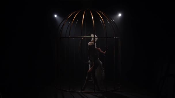 空中杂技在黑暗的房间里的金属笼子里旋转吊环上 黑色背景 慢动作 — 图库视频影像