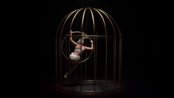 Antenne acrobatiek op een roterende hoepel in een metalen kooi. Zwarte achtergrond — Stockvideo