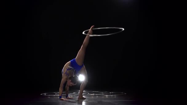 Mädchen turnen mit einem Gymnastikreifen. schwarzer Hintergrund — Stockvideo
