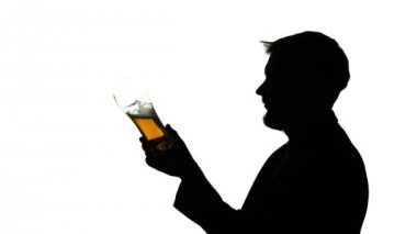 Adam bir bardak bira içiyor. Yan görünümü. Beyaz arka plan siluet