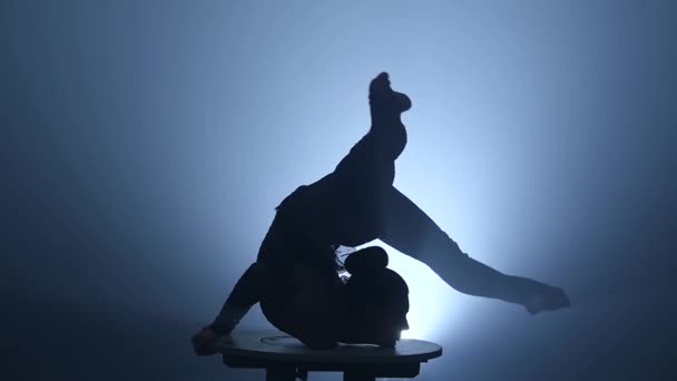 Gymnastka umělec vystupování na pódiu. Kouř na pozadí. Zpomalený pohyb. Silueta — Stock video