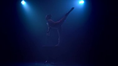 Kız masanın üzerinde havada dikey bir sicim gerçekleştirir. Mavi renkli duman. Ağır çekim. Siluet