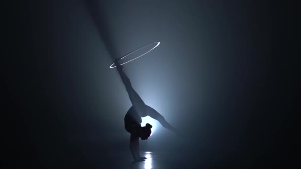 어두운 스튜디오에 그녀의 우아한 여자의 다리에는 후프를 배경입니다 슬로우 모션입니다 — 비디오