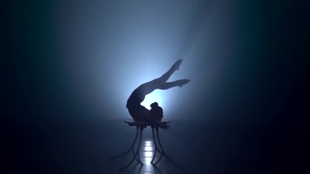 Acrobat på bordet visar knepen av stående på hennes händer. Rök bakgrund. Slow motion. Siluett — Stockvideo