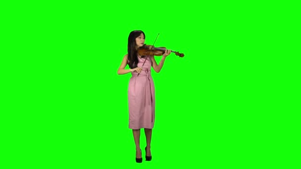 Flicka av asiatisk utseende spelar fiol. Grön skärm — Stockvideo