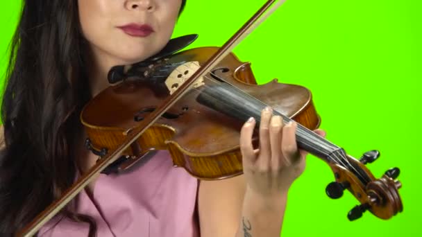 Mädchen, das die Saiten auf einer braunen Geige fingert. Nahaufnahme. Green Screen — Stockvideo