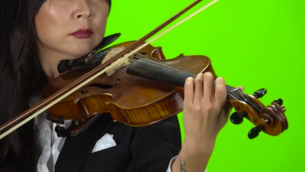 女人在拉小提琴时指指点点琴弦。闭上你的嘴绿色屏幕 — 图库视频影像