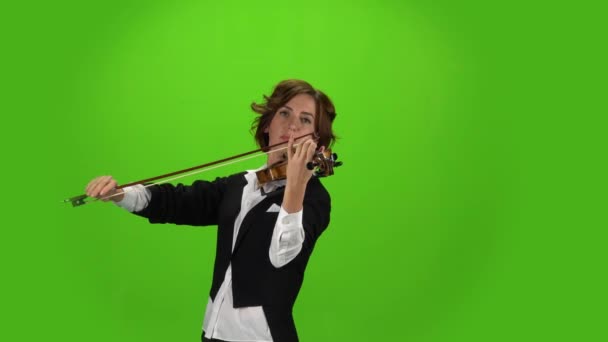 Девушка в пиджаке играет на скрипке. Зеленый экран — стоковое видео