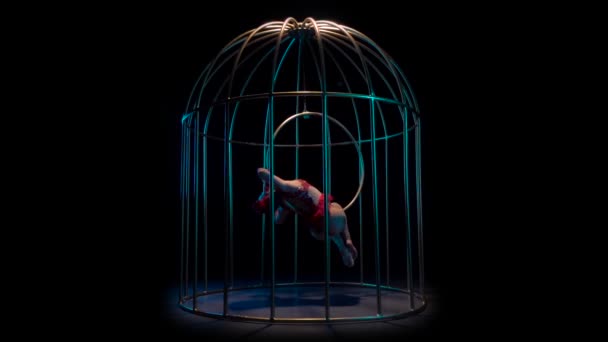 Actrice en costume rouge sur un cerceau de gymnastique effectue des tours dans une cage. Fond noir. Mouvement lent — Video