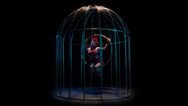 Acrobacias de arte menina em um aro rotativo em uma gaiola de metal. Fundo preto. Movimento lento — Vídeo de Stock