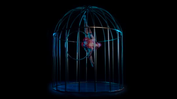 Acrobat spinning on a hoop in a cage. Black background. Slow motion — Stock Video