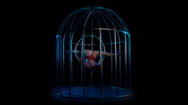 Gymnaste sur un cercle rotatif dans une cage métallique. Fond noir. Mouvement lent — Video