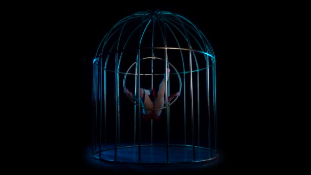 Κορίτσι σε ένα κλουβί εκτελεί διάφορες κινήσεις. Μαύρο φόντο. Αργή κίνηση — Αρχείο Βίντεο