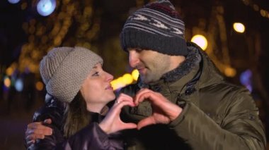Mutlu çift romantik taahhüt sevgi dolu ilişki zevk el hareketi el ile kalp şekil verme
