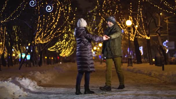 Vackra par dans och snurra i den fallande snön — Stockvideo