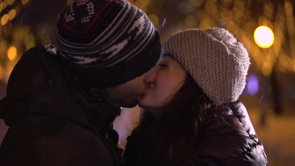 Чоловік обіймає і цілує дівчину вночі — стокове відео