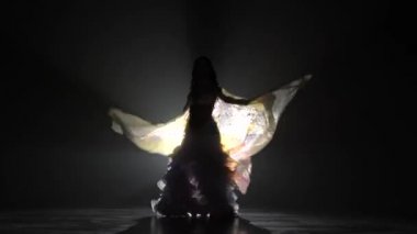 Dansçı kız beyaz takım elinde kanatları gibi döne döne. Duman arka plan