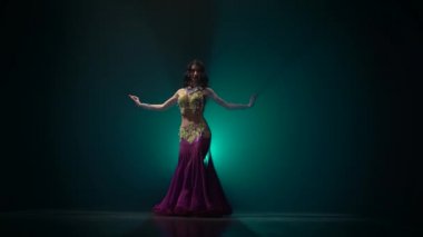 Güzel egzotik dansöz kız onu kalça sallayarak. Duman arka plan