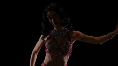 Parlak ince gövdesinde bir kız kadın dansçı. Siyah arka plan. Yavaş hareket