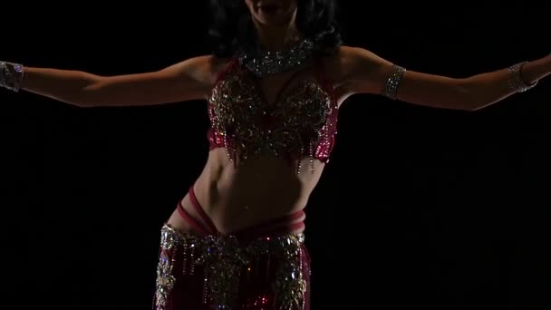 Bailarina árabe realiza danza del vientre en el escenario. Fondo negro. Movimiento lento — Vídeo de stock