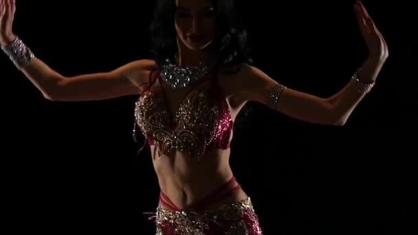 Girl performs belly dance in oriental costume. Black background. Slow motion — Stock Video