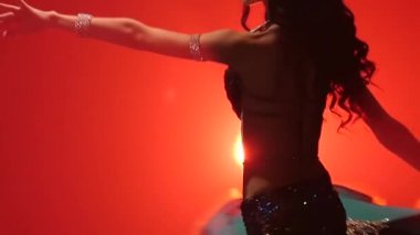Egzotik elbise dans kadın oryantal dansçı Arabian. Kırmızı duman arka planı. Yavaş hareket. Yakın çekim