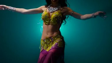 Egzotik bir kadın dansçının gövdesinde. Duman geçmişi. Yavaş hareket. Yakın çekim