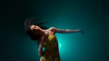 Arap dansçı sahnede oryantal dans gerçekleştirir. Duman geçmişi. Yavaş hareket. Yakın çekim