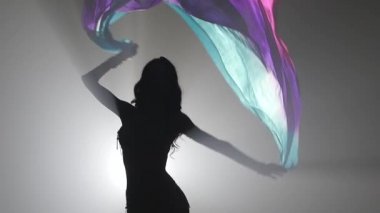 Elinde peçeli, göbek dansı yapan kadın. Sihouette, hayır. Duman geçmişi. Yavaş hareket. Yakın çekim