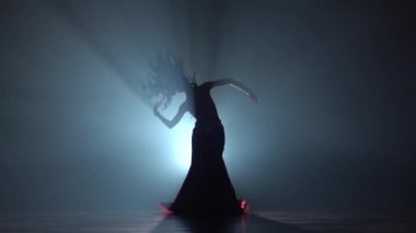 Oryantal dans yapan çekici bir kadın. Duman geçmişi. Sihouette, hayır. Yavaş hareket
