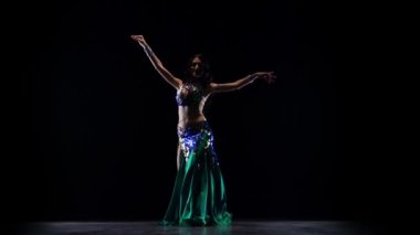 Geleneksel oryantal dansçı kız dans. Siyah arka plan. Yavaş hareket
