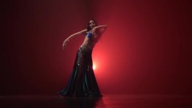 Geleneksel oryantal dansçı kadın dans. Kırmızı duman arka planı. Yavaş hareket