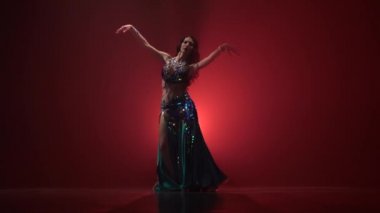 Göbek dansçı göbek hareketi modern dans Torso. Kırmızı duman arka planı. Yavaş hareket