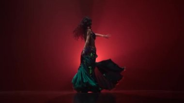 Oryantal dansçı Arap içinde egzotik elbise dans. Kırmızı duman arka planı. Yavaş hareket