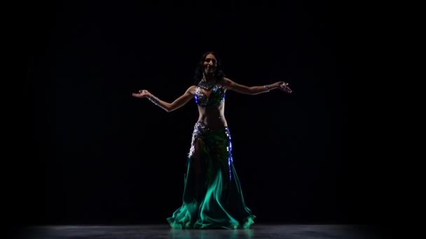 Vrouwelijke buikdanseres die begint te schudden haar heupen. Zwarte achtergrond. Slow Motion — Stockvideo